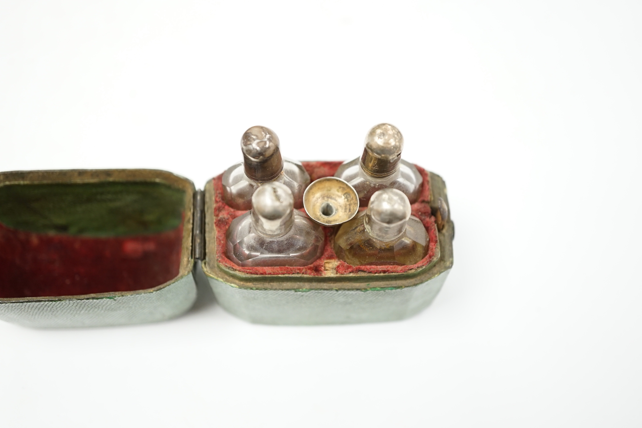 A set of four Dutch white metal mounted scent bottles, with funnel, housed in a shagreen case with hinged cover, case height 69mm.